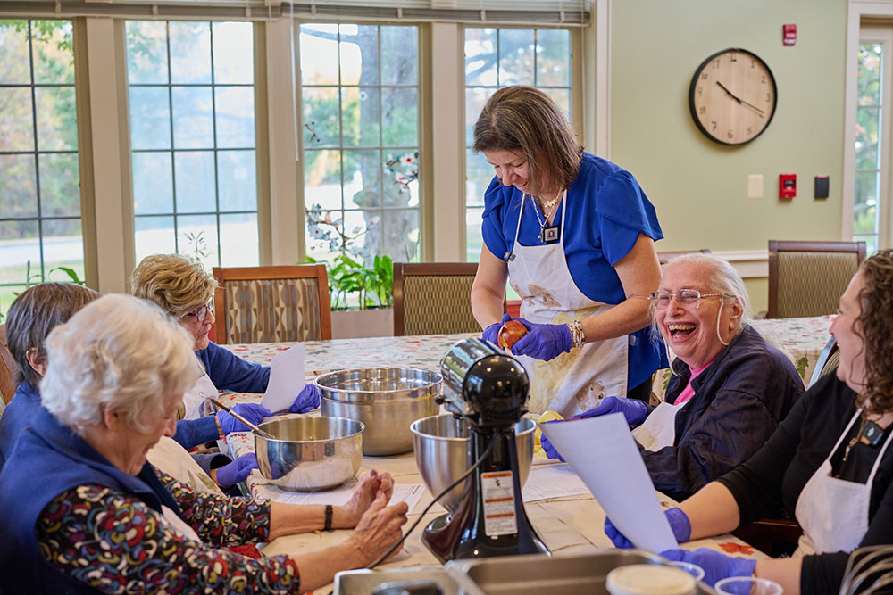group of women sitting around a table for a cooking demonstration