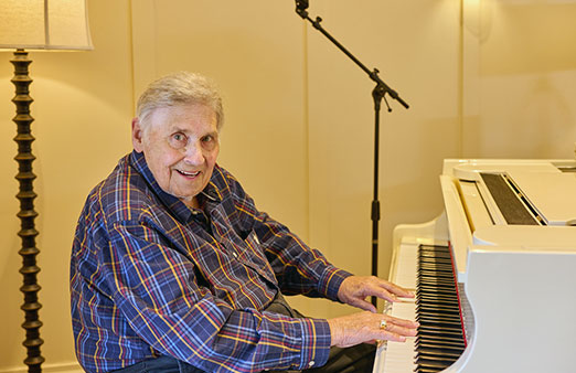 senior man sitting at a piano
